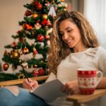 Portrait of a woman with pencil and notebook writing, at home. Christmas, winter, holidays and people concept. Noworoczne postanowienia w duchu prozdrowotnym: Jak zacząć zdrowy rok?
