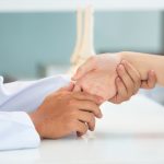 Asian doctor examining patient with wrist bone problems painful Choroba De Quervaina_zapalenie pochewek ścięgnistych nadgarstka Katowice Globiana